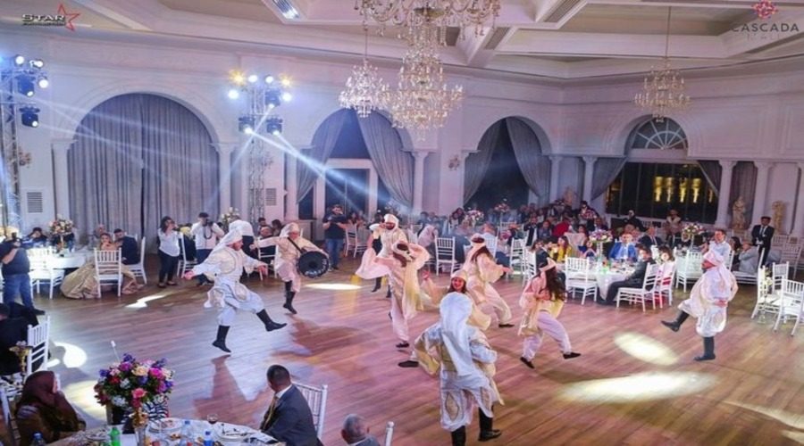 A dabke troupe performing on the ballroom floor under stage lighting